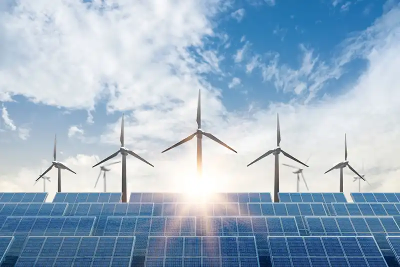 Solar cell plant and wind generators under blue sky on sunset